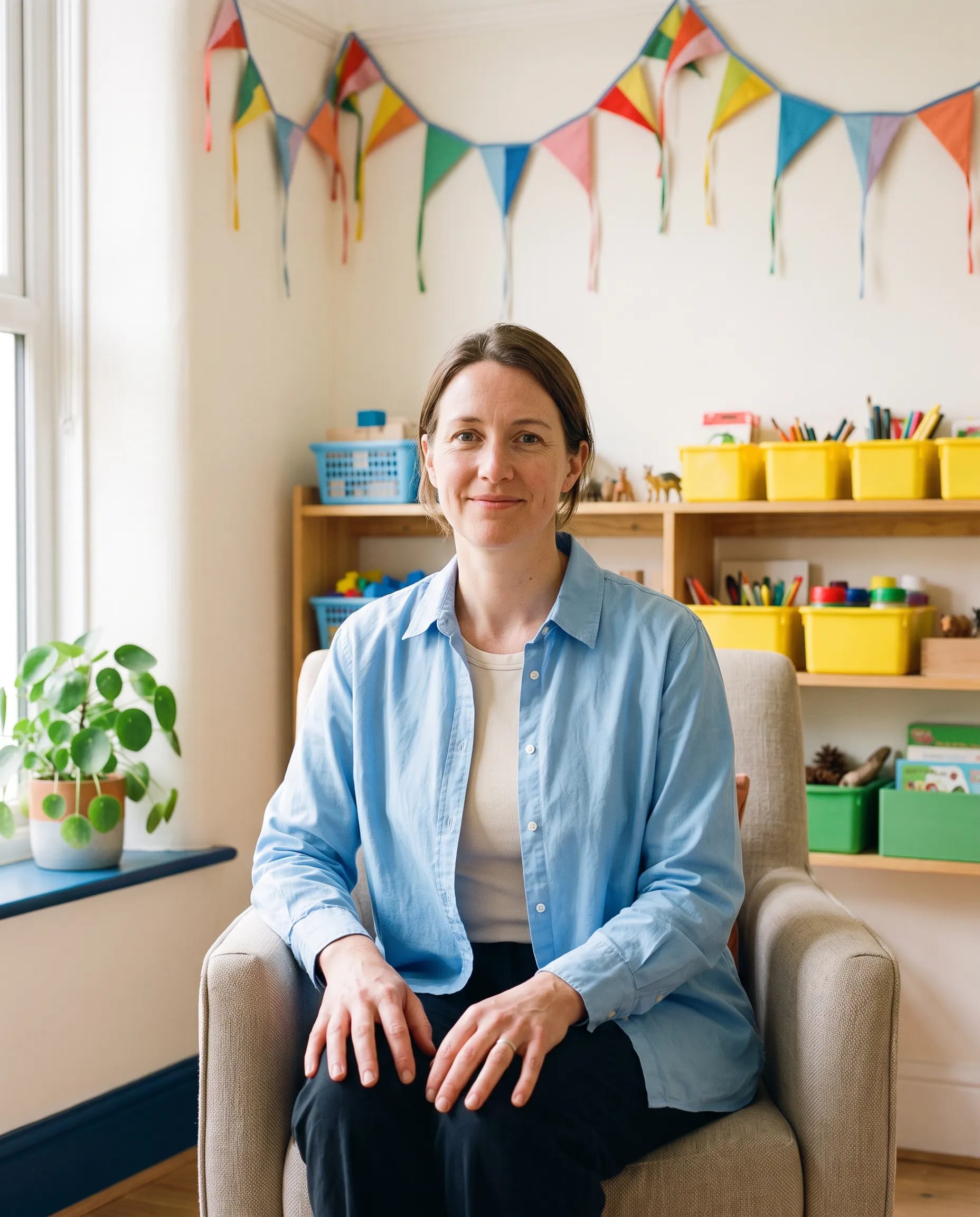 Seren Hughes, play therapist, seated in the Little Kite playroom in Pontcanna, Cardiff, warm and direct to camera